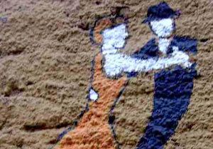 Rysunek na murze przedstawiający parę tańczącą tango.
